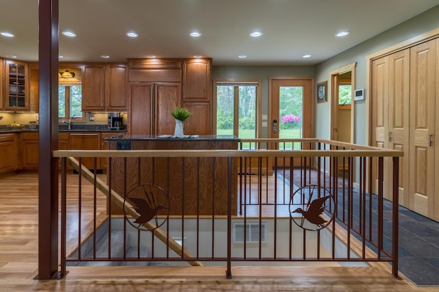 27766 County 37, Laporte, MN 56461 - kitchen with dark countertops, brown cabinetry, recessed lighting, glass insert cabinets, and a breakfast bar area