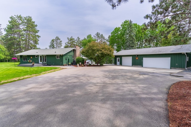 27766 County 37, Laporte, MN 56461 - single story home featuring a detached garage, a front yard, a chimney, board and batten siding, and driveway