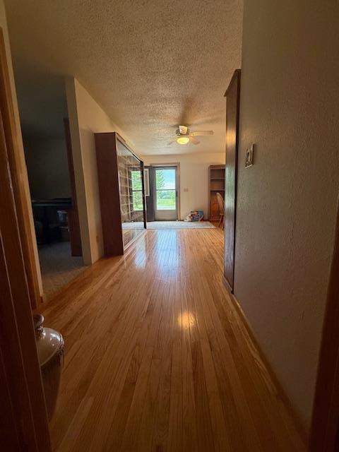 20501 Nebish Rd NE, Blackduck, MN 56630 - unfurnished living room featuring a textured ceiling, wood finished floors, and a ceiling fan
