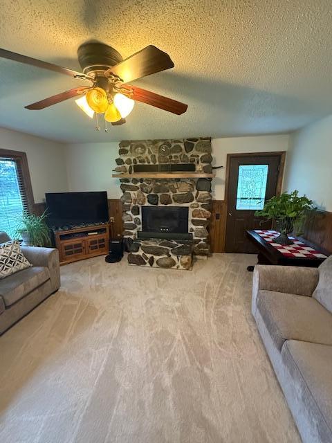 20501 Nebish Rd NE, Blackduck, MN 56630 - living area featuring carpet floors, plenty of natural light, a textured ceiling, a fireplace, and a ceiling fan