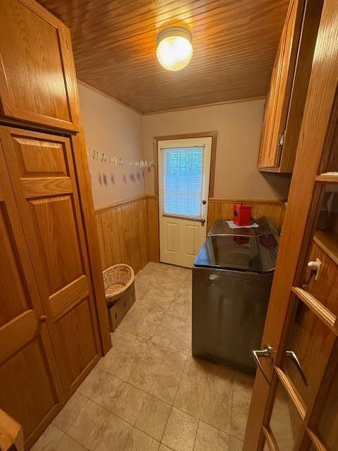 20501 Nebish Rd NE, Blackduck, MN 56630 - washroom with a wainscoted wall, cabinet space, wood walls, light tile patterned flooring, and wood ceiling