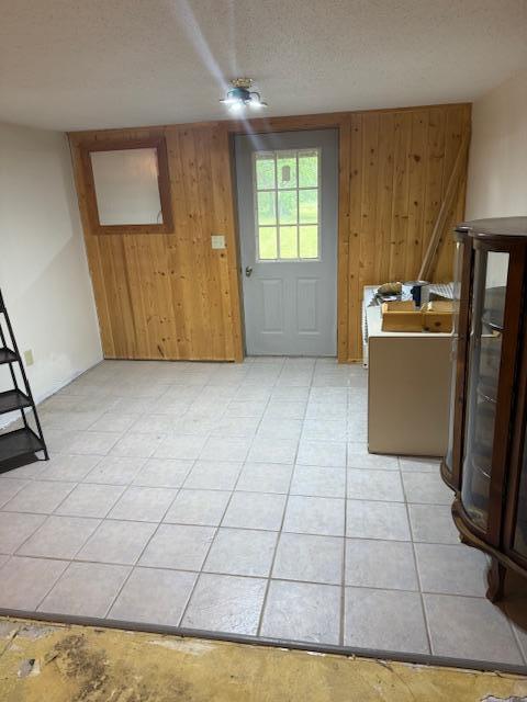 20501 Nebish Rd NE, Blackduck, MN 56630 - entryway featuring wood walls, a textured ceiling, and light tile patterned flooring