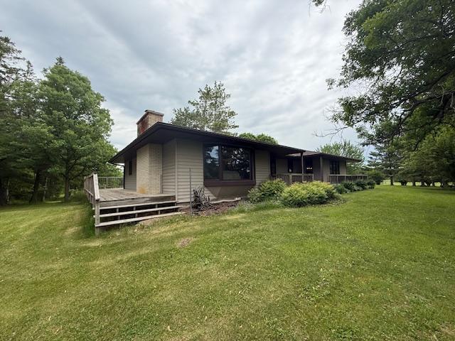 20501 Nebish Rd NE, Blackduck, MN 56630 - rear view of house featuring a chimney, a lawn, and a deck