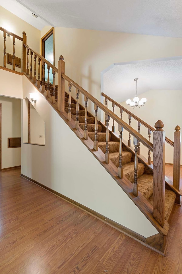 11606 235th St E, Lakeville, MN 55044 - stairs with wood finished floors, a chandelier, baseboards, and vaulted ceiling