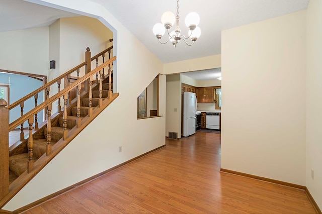 11606 235th St E, Lakeville, MN 55044 - staircase featuring wood finished floors, a chandelier, and baseboards