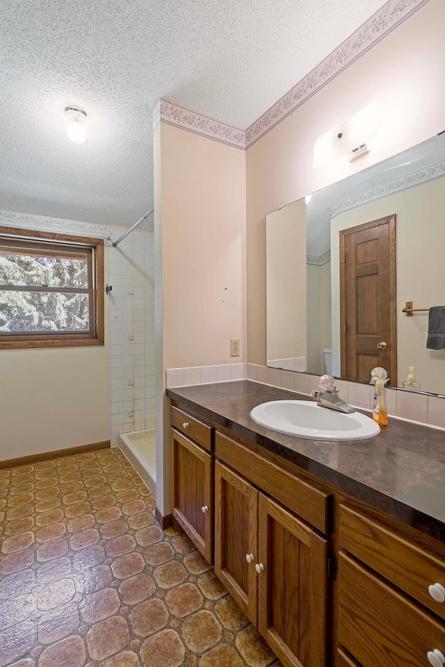 11606 235th St E, Lakeville, MN 55044 - full bath with a textured ceiling, vanity, a tile shower, and baseboards