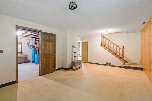11606 235th St E, Lakeville, MN 55044 - finished below grade area with stairs, a textured ceiling, a water softener, baseboards, and wood walls