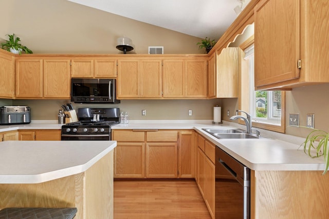 6449 151st St N, Hugo, MN 55038 - kitchen featuring appliances with stainless steel finishes, a sink, vaulted ceiling, light wood-type flooring, and light countertops
