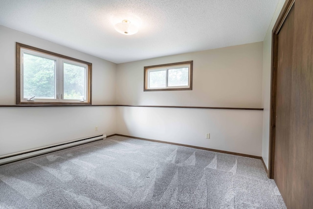 20619 Hillcrest Rd, Elizabeth Twp, MN 56537 - empty room with carpet flooring, a baseboard radiator, a textured ceiling, and baseboards