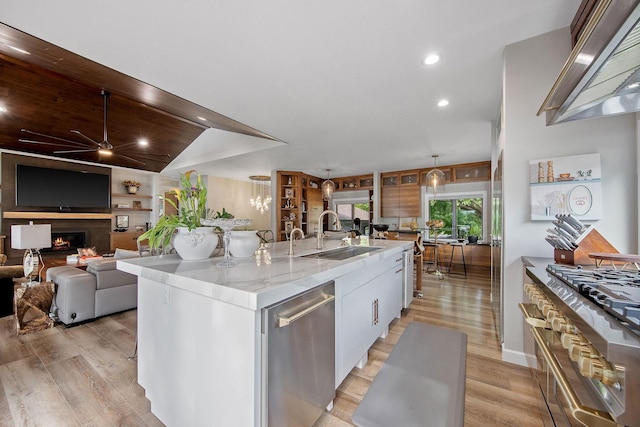 2311 Swan Dr, Mendota Heights, MN 55120 - kitchen featuring wall chimney range hood, ceiling fan, appliances with stainless steel finishes, light wood-style floors, and a sink