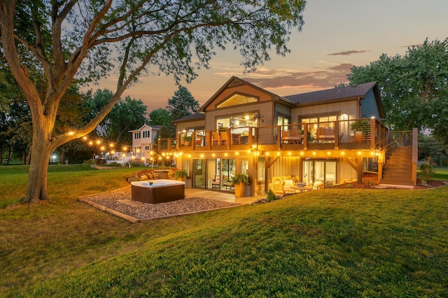 2311 Swan Dr, Mendota Heights, MN 55120 - back of house at dusk with a hot tub, a yard, a patio, stairs, and board and batten siding