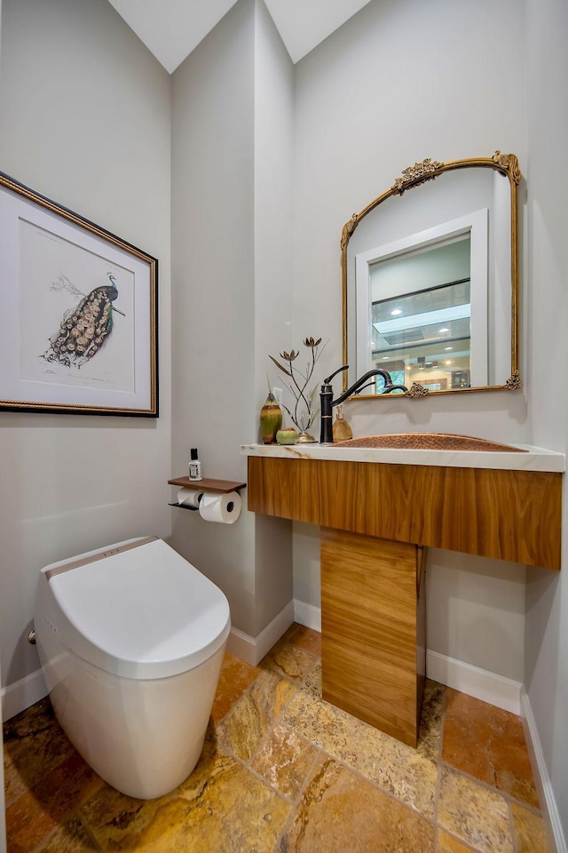 2311 Swan Dr, Mendota Heights, MN 55120 - bathroom with stone finish floors, toilet, a sink, and baseboards