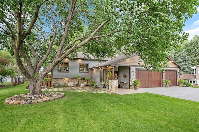 2311 Swan Dr, Mendota Heights, MN 55120 - tri-level home featuring stone siding, a front lawn, concrete driveway, and an attached garage