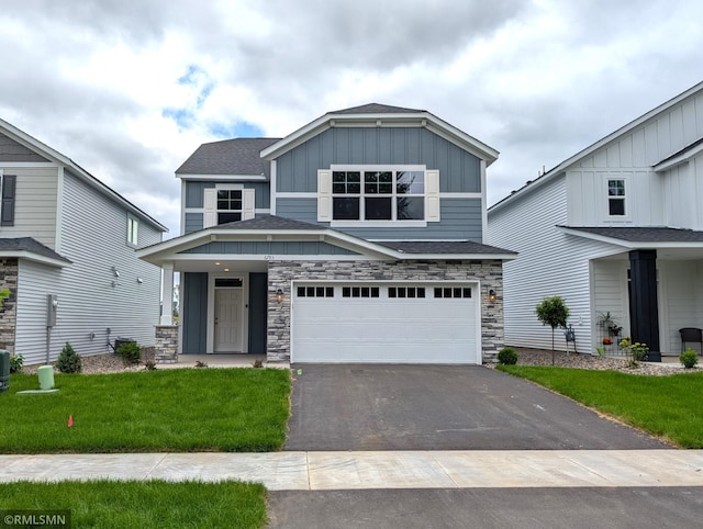 6785 104th St S, Cottage Grove, MN 55016 - view of front of home with board and batten siding, asphalt driveway, an attached garage, and stone siding