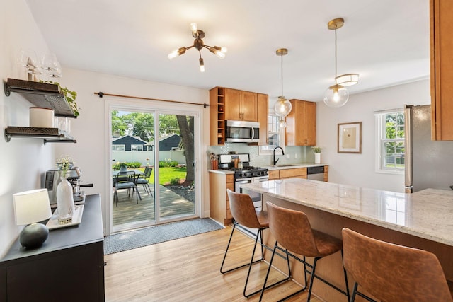 6233 4th Ave S, Richfield, MN 55423 - kitchen with open shelves, stainless steel appliances, a sink, light wood-style floors, and backsplash
