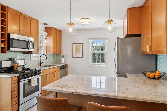 6233 4th Ave S, Richfield, MN 55423 - kitchen with appliances with stainless steel finishes, a sink, a peninsula, light stone countertops, and backsplash