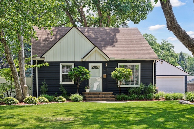 6233 4th Ave S, Richfield, MN 55423 - view of front of house with entry steps, a front lawn, a detached garage, a shingled roof, and an outbuilding