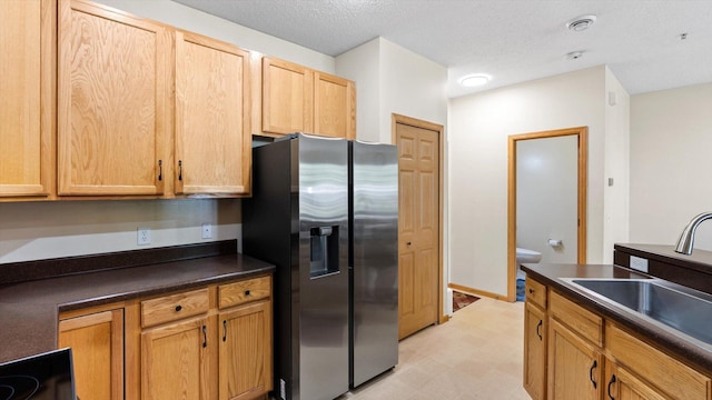 13749 Atrium Ave Unit 2303, Rosemount, MN 55068 - kitchen featuring stainless steel refrigerator with ice dispenser, dark countertops, light floors, a sink, and a textured ceiling