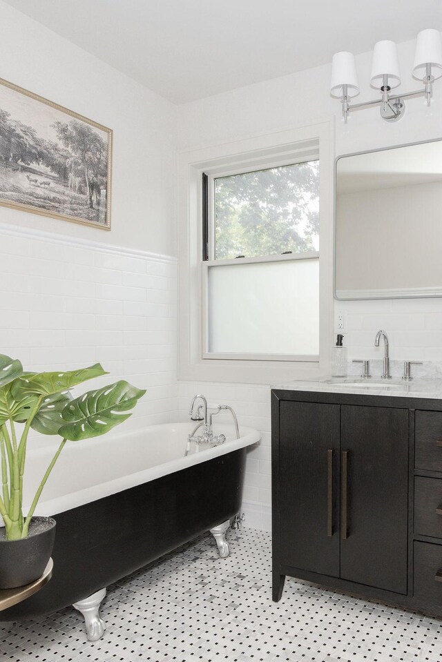 2137 Wellesley Ave, Saint Paul, MN 55105 - bathroom featuring a freestanding bath, tile walls, vanity, and a wainscoted wall
