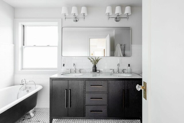 2137 Wellesley Ave, Saint Paul, MN 55105 - full bathroom featuring tile walls, a freestanding tub, double vanity, and a wainscoted wall