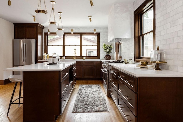 2137 Wellesley Ave, Saint Paul, MN 55105 - kitchen featuring stainless steel appliances, a breakfast bar area, plenty of natural light, and light countertops