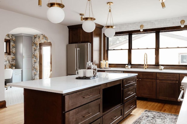 2137 Wellesley Ave, Saint Paul, MN 55105 - kitchen with arched walkways, high end refrigerator, healthy amount of natural light, and light countertops