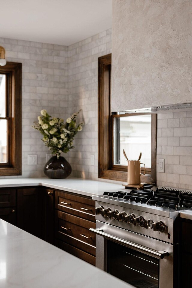 2137 Wellesley Ave, Saint Paul, MN 55105 - kitchen with stainless steel range, light countertops, dark brown cabinets, and range hood
