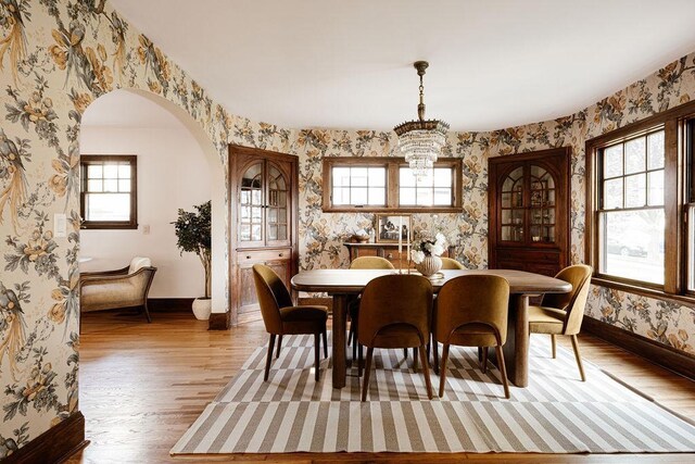2137 Wellesley Ave, Saint Paul, MN 55105 - dining area with wallpapered walls, healthy amount of natural light, wood finished floors, arched walkways, and a chandelier