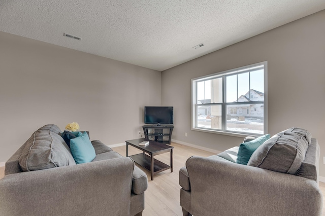 2605 Hanson Ave, Faribault, MN 55021 - living room featuring light wood finished floors, a textured ceiling, and baseboards