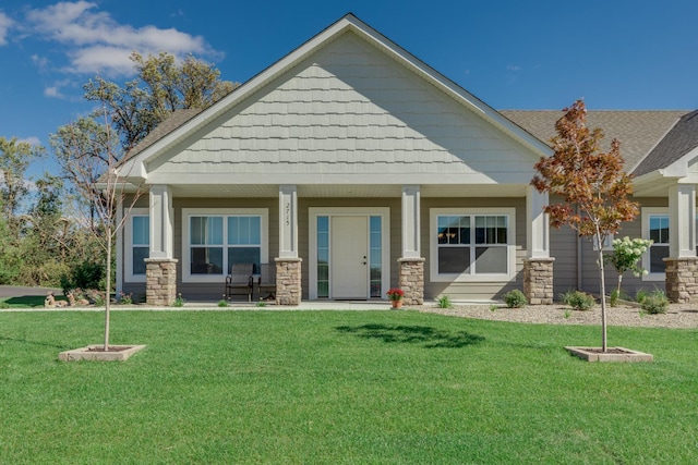 2605 Hanson Ave, Faribault, MN 55021 - craftsman inspired home featuring a porch, a front lawn, stone siding, and a shingled roof