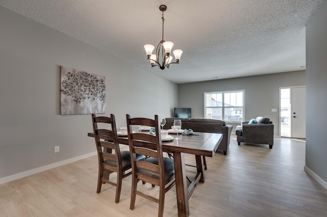 2605 Hanson Ave, Faribault, MN 55021 - dining room with a textured ceiling, light wood finished floors, a chandelier, and baseboards
