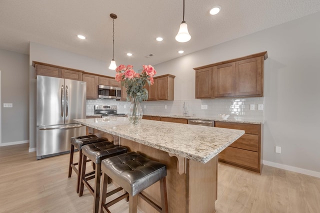 2605 Hanson Ave, Faribault, MN 55021 - kitchen with appliances with stainless steel finishes, a sink, light wood-style floors, a kitchen island, and recessed lighting