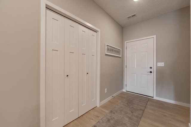 2605 Hanson Ave, Faribault, MN 55021 - foyer entrance with light wood-type flooring, baseboards, and a textured ceiling