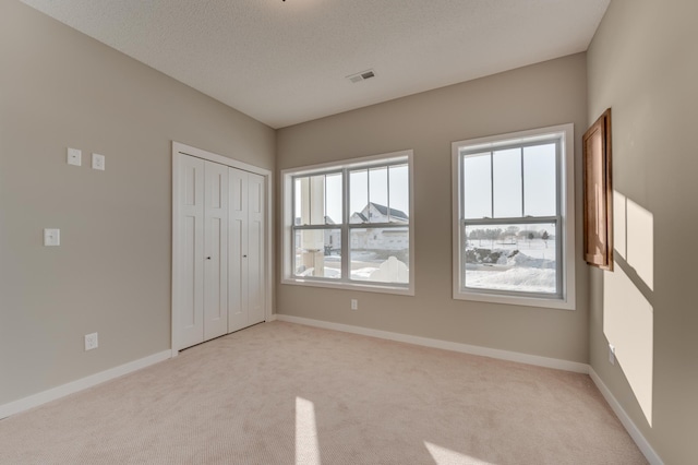 2605 Hanson Ave, Faribault, MN 55021 - unfurnished bedroom featuring light carpet, baseboards, and a closet