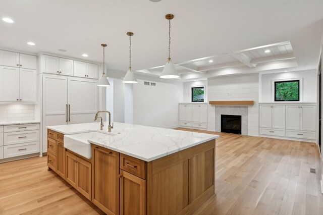 5924 Drew Ave S, Edina, MN 55410 - kitchen featuring a sink, recessed lighting, light wood-style floors, an island with sink, and light stone countertops