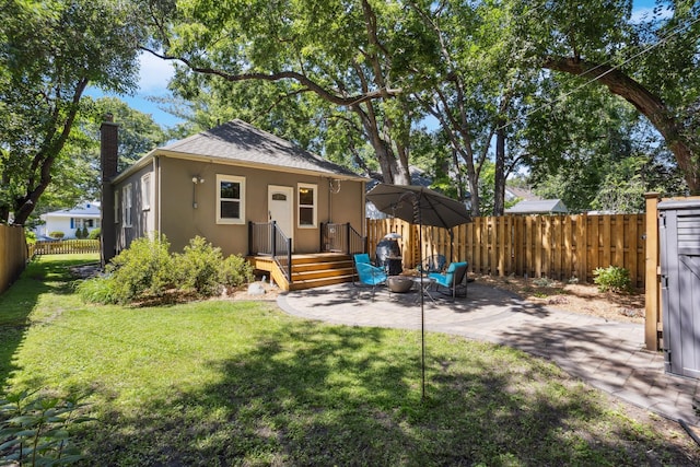 4545 5th Ave S, Minneapolis, MN 55419 - back of house featuring stucco siding, a fenced backyard, a chimney, and a patio area