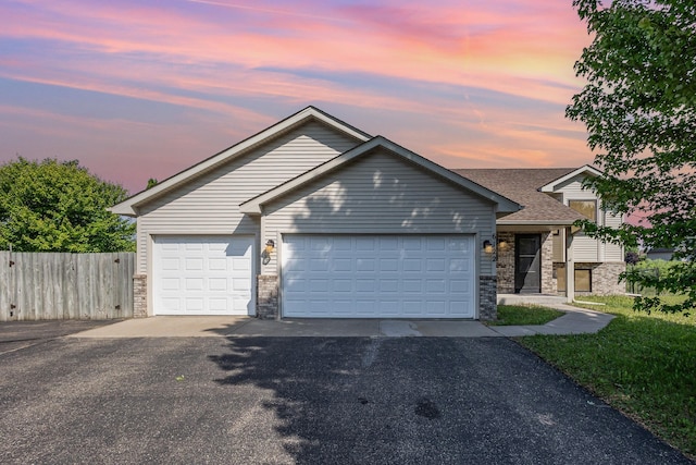 6122 152nd St N, Hugo, MN 55038 - view of front facade with asphalt driveway, a garage, and stone siding