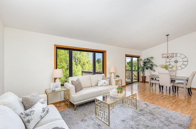 6122 152nd St N, Hugo, MN 55038 - living room featuring a chandelier, wood finished floors, vaulted ceiling, and baseboards