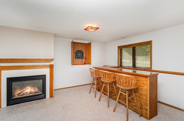 6122 152nd St N, Hugo, MN 55038 - dining room featuring a bar, baseboards, a glass covered fireplace, and carpet floors