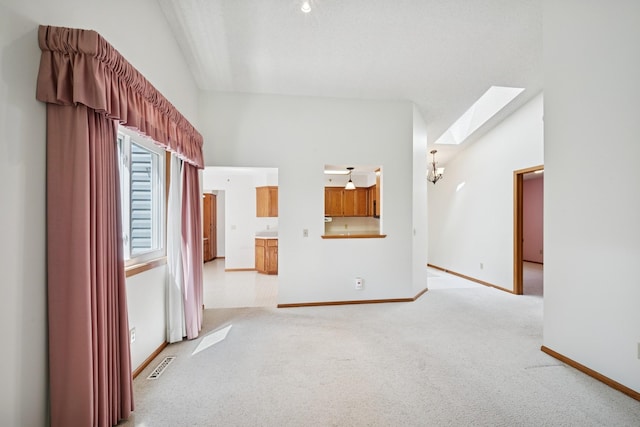 2639 Lake Court Cir Unit 81, Mounds View, MN 55112 - empty room with a skylight, light colored carpet, baseboards, and high vaulted ceiling