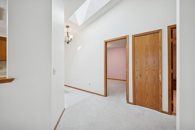 2639 Lake Court Cir Unit 81, Mounds View, MN 55112 - hallway featuring a skylight, carpet flooring, lofted ceiling, and baseboards