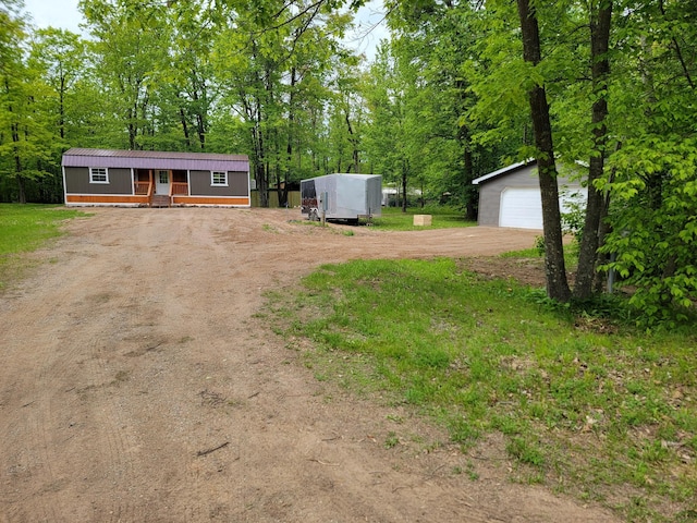 46625 High Dr, Kathio Twp, MN 56450 - view of front facade with dirt driveway, an outdoor structure, a porch, and a garage