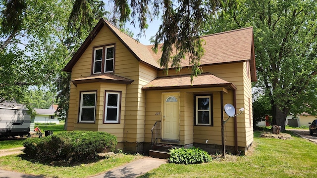 229 2nd Ave, Wanamingo, MN 55983 - view of front of home with roof with shingles and a front yard