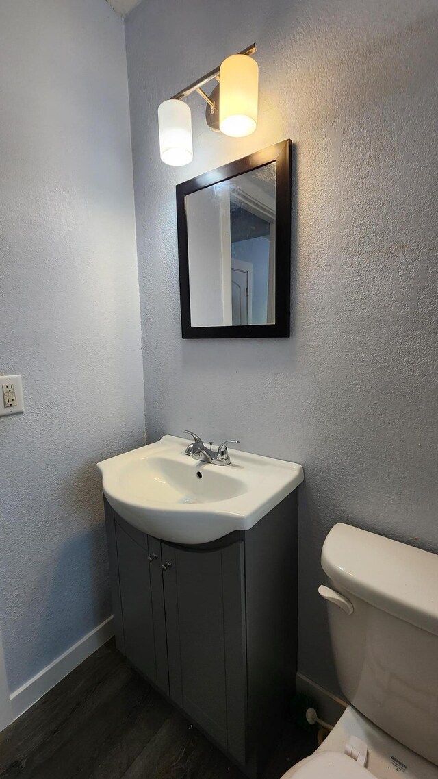 229 2nd Ave, Wanamingo, MN 55983 - bathroom with vanity, toilet, wood finished floors, and baseboards