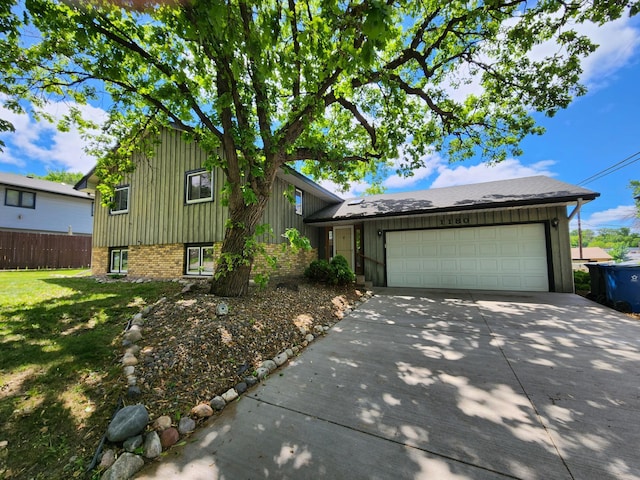 1180 Hathaway Ln NE, Fridley, MN 55432 - split level home with a garage, driveway, board and batten siding, and brick siding