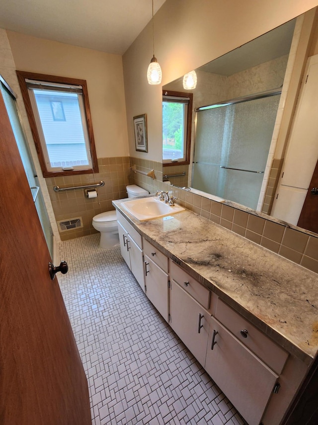 1180 Hathaway Ln NE, Fridley, MN 55432 - bathroom featuring plenty of natural light, toilet, a shower with door, vanity, and tile walls