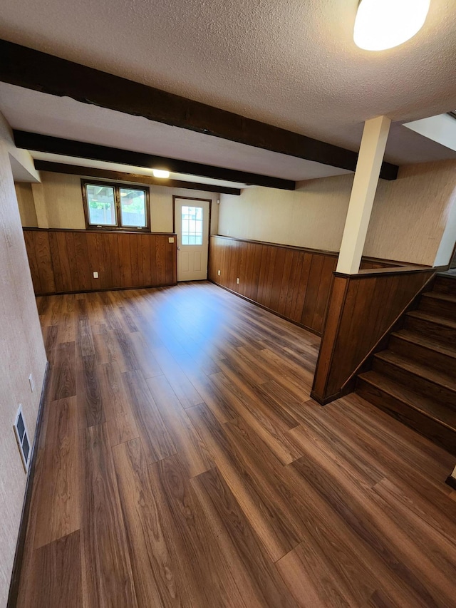 1180 Hathaway Ln NE, Fridley, MN 55432 - below grade area featuring wooden walls, a textured ceiling, wood finished floors, wainscoting, and stairway