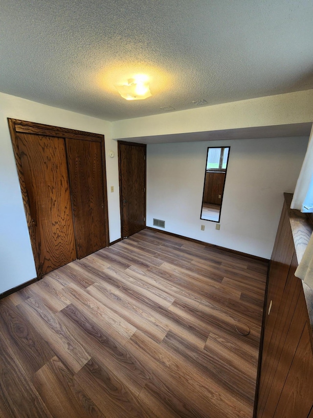 1180 Hathaway Ln NE, Fridley, MN 55432 - unfurnished bedroom with wood finished floors, a textured ceiling, and baseboards