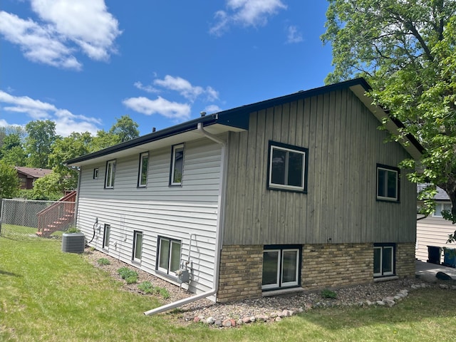 1180 Hathaway Ln NE, Fridley, MN 55432 - view of home's exterior with a yard, central AC, and board and batten siding