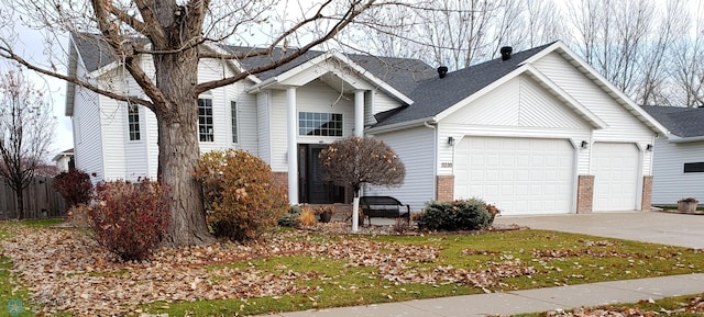 3235 37th Ave S, Fargo, ND 58104 - view of front facade featuring an attached garage, concrete driveway, brick siding, and a shingled roof